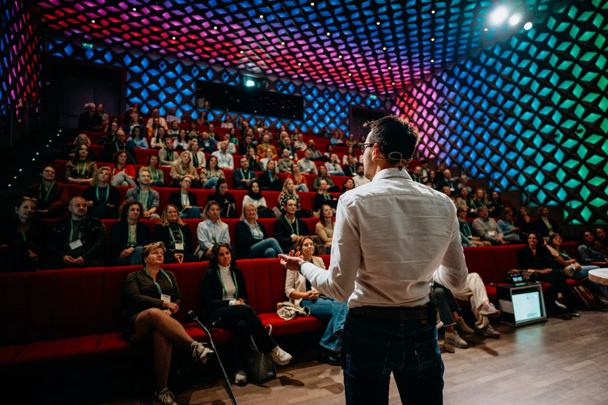 Jens van der Weele spreekt voor een volle zaal